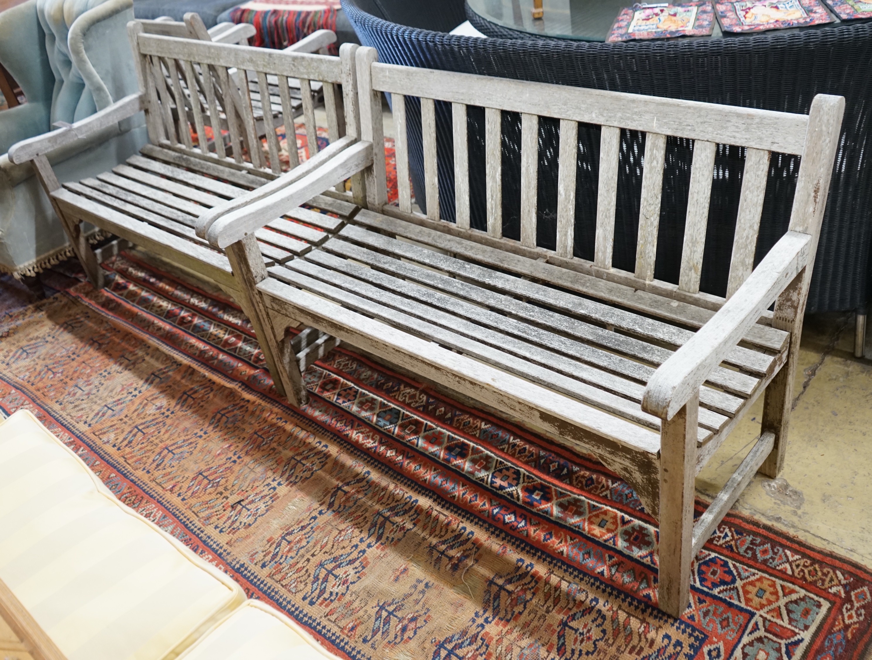 A pair of weathered teak slatted garden benches, each length 121cm, depth 56cm, height 85cm